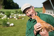 Landwirt Josef Wimmer mit einem seiner Masthühner der Rasse ISA757 vor dem Auﬂengelände. Betrieb: Wimmer, Maitenbeth  (©Foto: Tobias Hase)